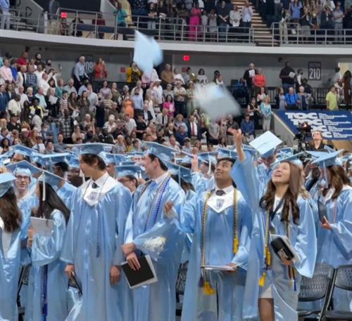 Group pic of graduates from James Clemens High School tossing hats in air
